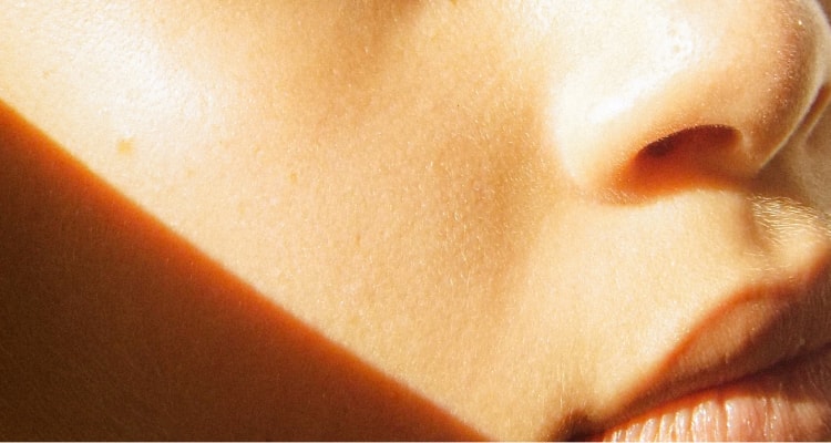 Female model side glancing at the camera with sunlight lighting up her face