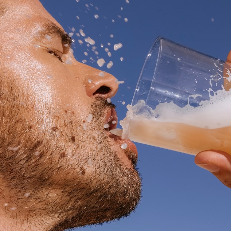 A man with a beard drinking peach persimmon ARMRA