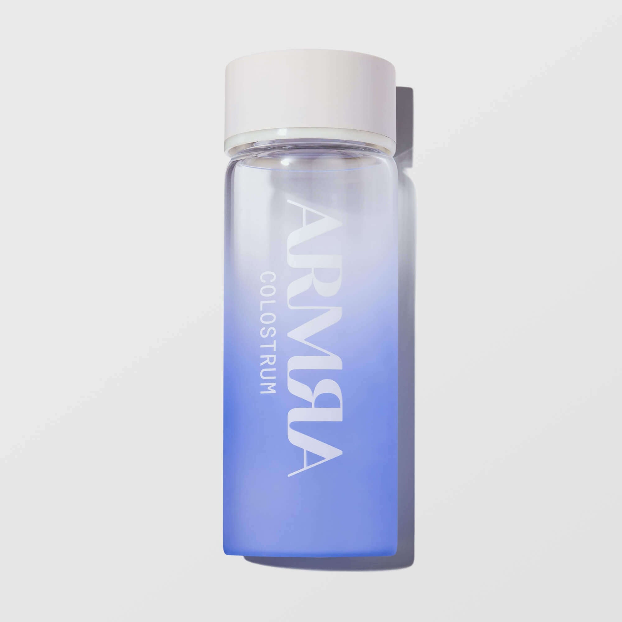 Purple bottle with white cap and 'ARMRA' branding on a light gray background